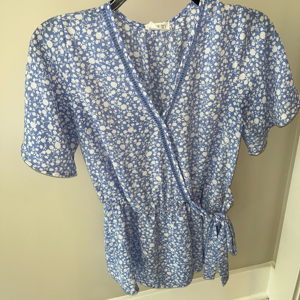 Light blue and white floral wrap top.